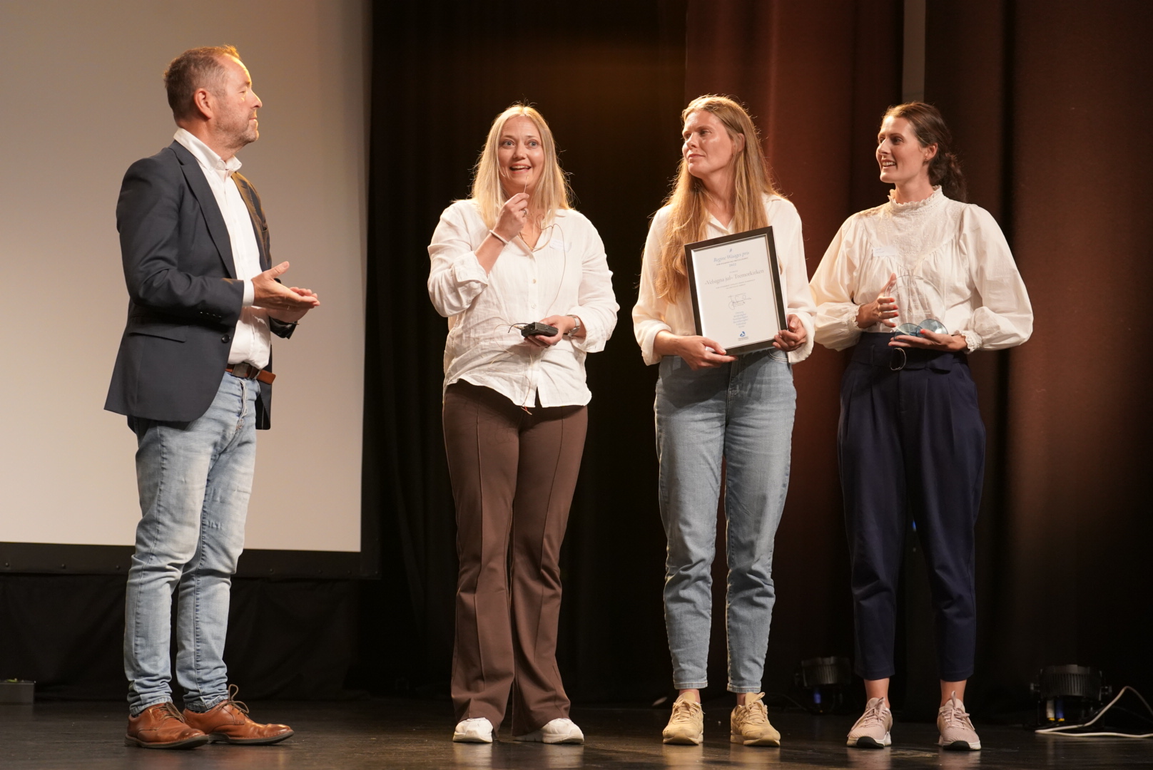 Representanter fra Tremor kirken sitt diakonale arbeid "Velsigna jul" mottar Regine Waages pris for diakoni og frivillighet.