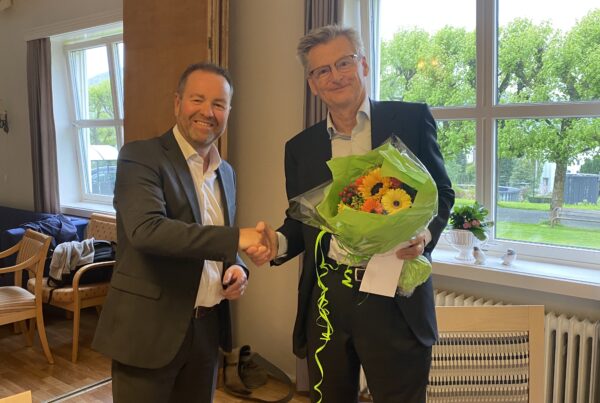 Adm.dir. i Haraldsplass Diakonale Stiftelse, Jørn-Henning Theis overrakte blomster og takk til avtroppende styreleder Johan Fredrik Odfjell på representantskapsmøtet 25.mai 2023.
