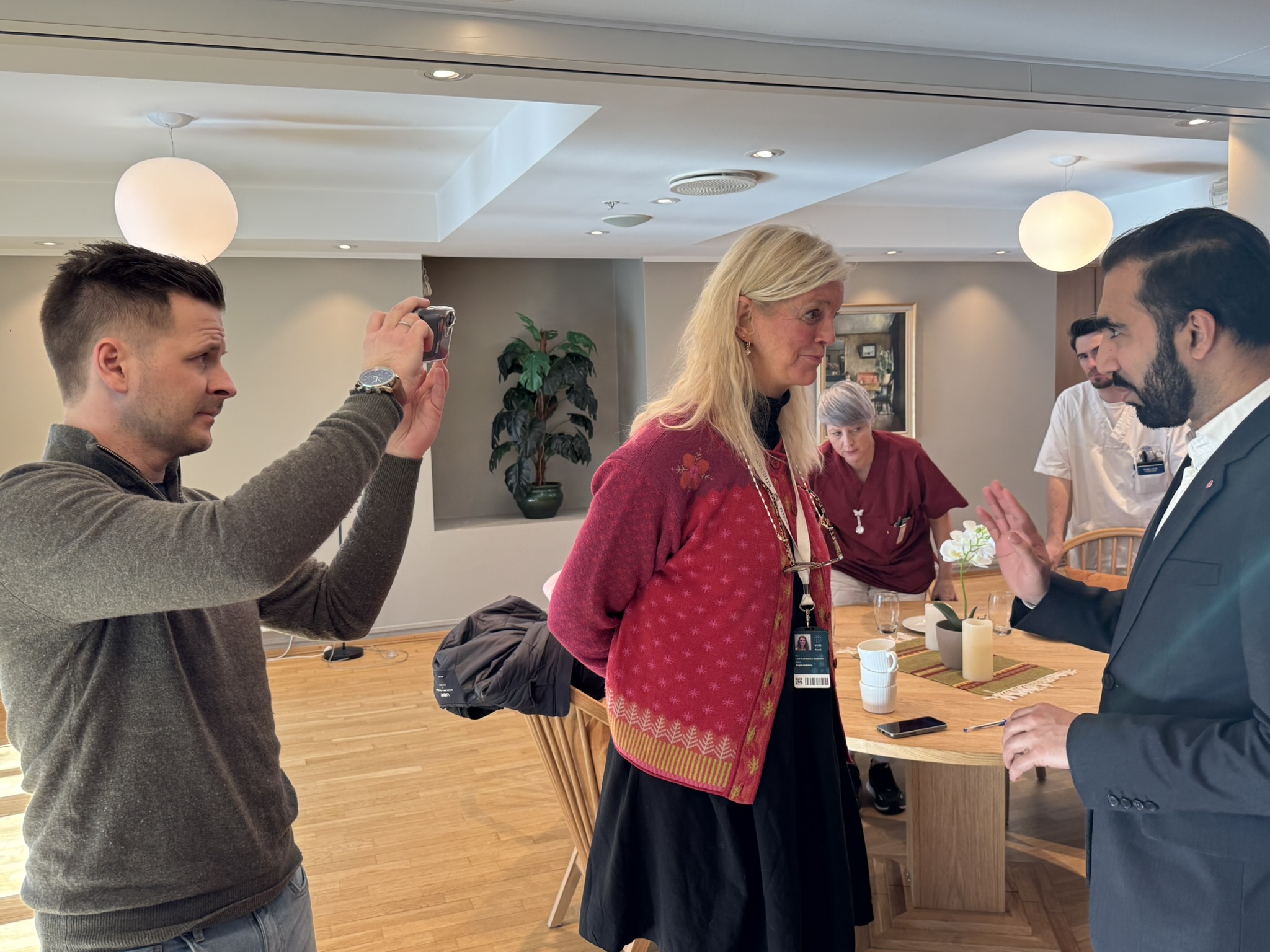 Journalist Martin Næss Kristiansen fra Dagsavisen tar bilde av forsker Line Constance Holmsen og statssekretær i Helse- og omsorgsdepartementet, Usman Mushta.